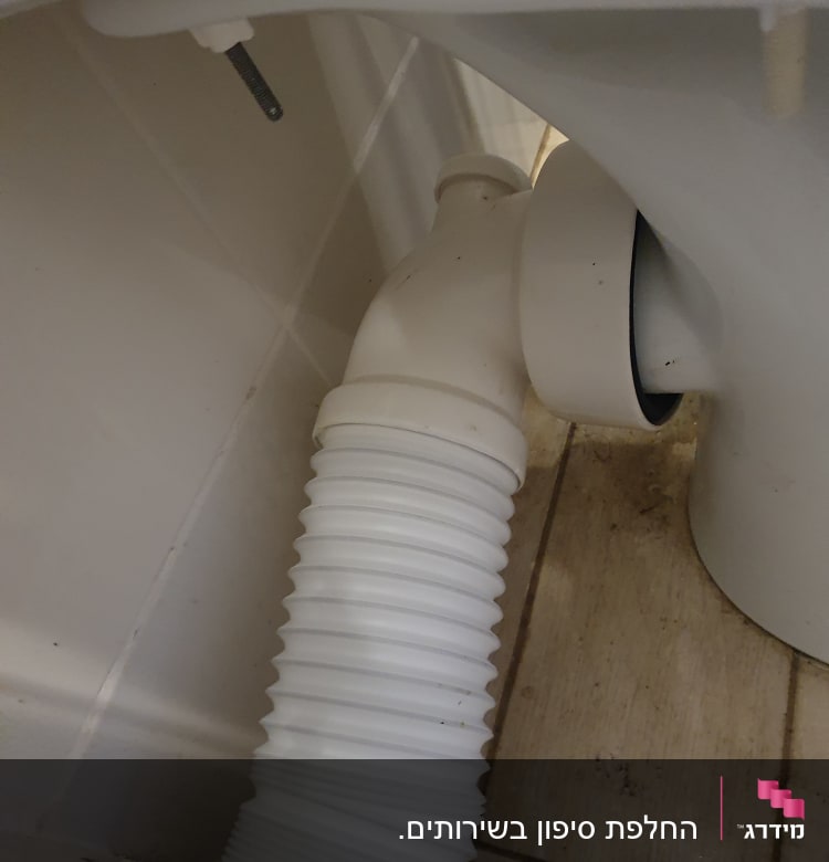 צינור גמיש מחובר לאסלה בחדר אמבטיה